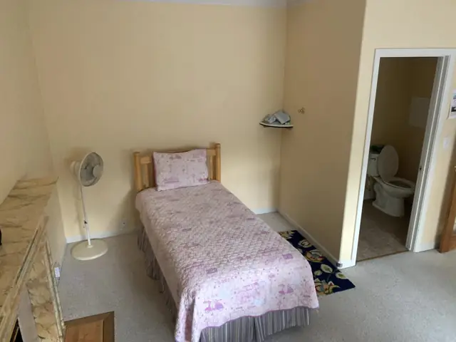 A private resident bedroom with a sunny window and an ensuite bathroom just off the room